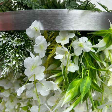 Hanging hoop with a mixture of artificial green plants with white trailing flowers 60cm diameter